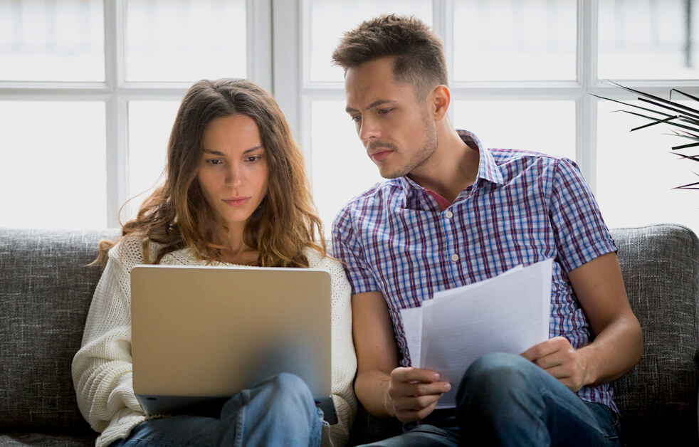 Couple Reading Home Insurance Policy For Claim