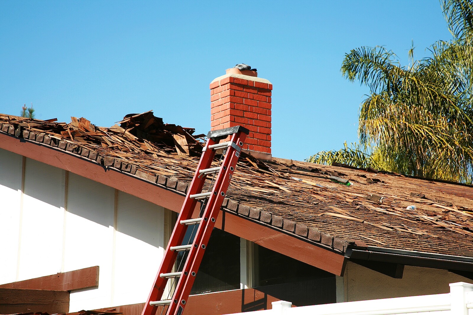 House with Roof Damage and Ladder